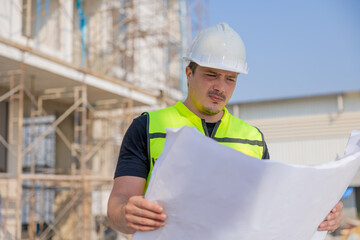 Construction Worker Reviewing Blueprints at Building Site