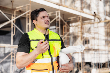 Construction Engineer Using Walkie Talkie at Building Site