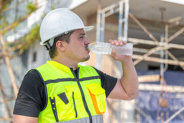 Hot Tired Thirsty Construction Worker Drinking Water on the Job Site