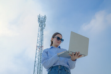 Woman Using Laptop Near Communication Tower Wireless Digital Data on blue sky