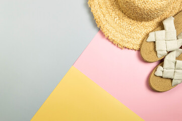 Top view of straw hat and slippers on colorful background. Summer fashion, vacation and beach...