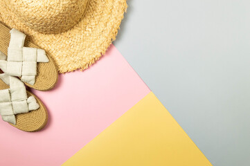 Top view of straw hat and slippers on colorful background. Summer fashion, vacation and beach...