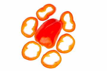 Red sweet ripe pepper cut into circles,slices on white