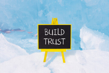 Build trust symbol. Concept words Build trust on beautiful yellow black blackboard. Beautiful blue...