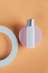 Plastic white tube for cream or lotion. Skin care or sunscreen cosmetic with stylish props on cream background.