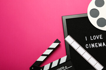 Clapperboard, reel, film and letter board on pink background, space for text