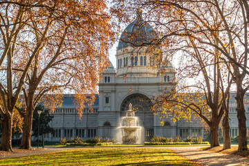 The historic Royal Exhibition Building and autumn trees bathed in morning sunlight in Carlton...