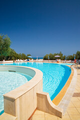 Swimming pool on sunny day by sea