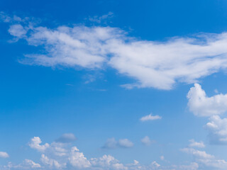 Green grass field on small hills and blue sky with clouds