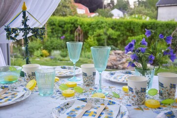 Table setting for the Midsommar holiday, with themed disposable tableware.