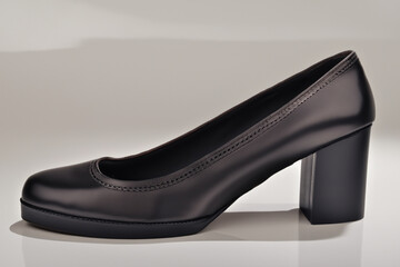 women's shoes. a classic black shoe stands on a gray background, close-up shoe concept