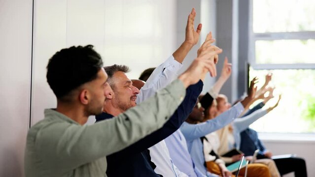 Business People Vote And Raise Questions At Team Event