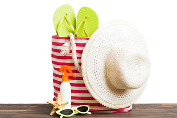 Stylish bag with beach accessories . Summer holiday concept. Top view of beach bag with sunscreen...