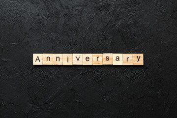 anniversary word written on wood block. anniversary text on cement table for your desing, concept