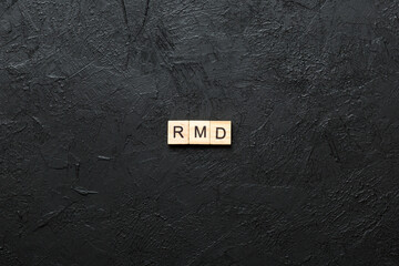 RMD word written on wood block. Required Minimum Distributions text on table, concept