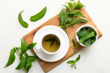 Cup of mint tea on table background. Green tea with fresh mint top view with copy space