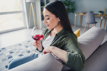 Photo of pretty young lady closed eyes smell wine wear green shirt weekend modern apartment indoors