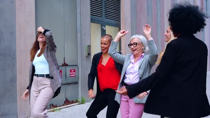 group of corporate successful women with their leader or boss of the office building dance happy for their success. outdoor