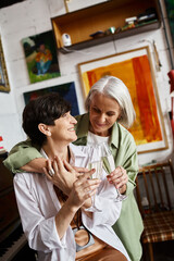 Two woman holding a glass of wine.