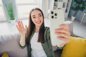 Photo of pretty young woman arm wave hi make selfie phone wear shirt modern interior apartment...