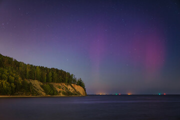 Baltic cliff in Gdynia Orlowo at night with Northerm lights over the sea. Poland
