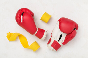 Red boxing gloves on color background, top view.