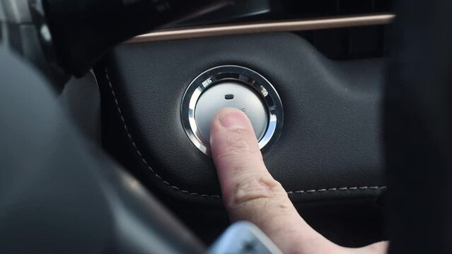 Male hand presses car engine start button. Engine stop start button.