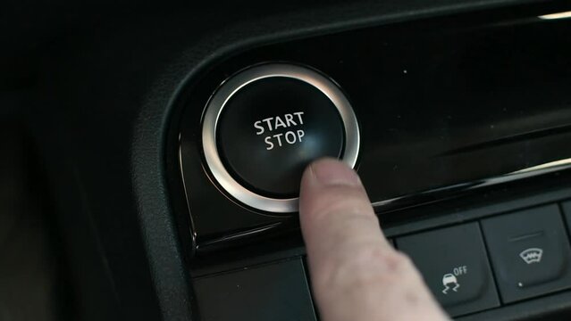 Male hand presses car engine start button. Engine stop start button.