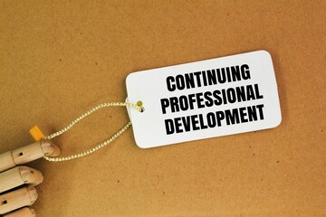 wooden hand and white paper tag with the words Continuing Professional Development