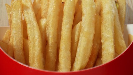 French fries are crispy potato slices typically deep-fried until golden brown. They're a beloved fast food staple, enjoyed worldwide for their crunchy exterior and fluffy interior. Junk food concept.
