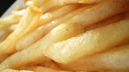 French fries are a popular side dish made from deep-fried potato strips. They're crispy on the outside and fluffy on the inside, often seasoned with salt or other spices. Fast-food background. 
