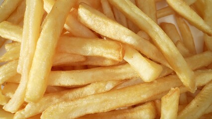 Crispy, golden French fries, beloved worldwide, are thinly sliced potatoes deep-fried to perfection, offering a delightful crunch and irresistible flavor. Food concept. French fries background. 
