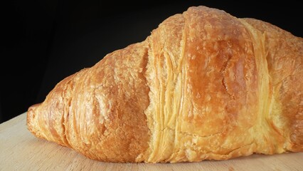 A croissant is a buttery, flaky, crescent-shaped pastry that originated in France. It is made from layered yeast-leavened dough, which is folded and rolled several times in succession. Food concept. 

