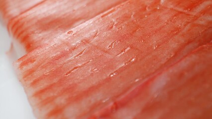 Crab sticks are made by grinding fish meat with starch, egg whites, flavorings, and sometimes crab extract. The mixture is shaped into sticks, cooked, cooled, and packaged for sale. Food concept.
