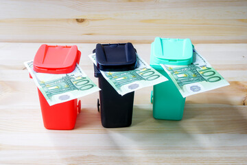 Euro Geldschein in einer M&uuml;lltonne als Symbol f&uuml;r M&uuml;llgeb&uuml;hren, Geldverschwendung