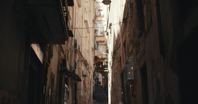 Narrow dark street stairs balcony laundry dry tilt up in Naples Italy