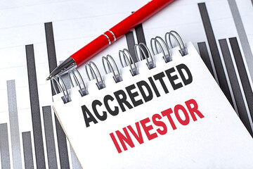 ACCREDITED INVESTOR text on notebook on chart with pen