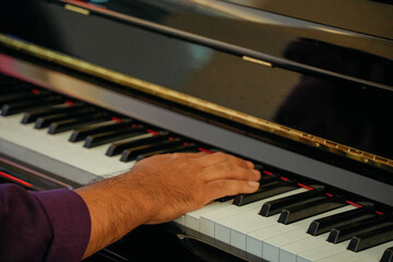 Male pianist playing piano, close-up
