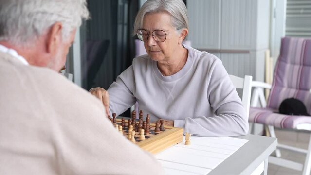 Pensioners pastime at senior home. Aged couple playing chess. Activities for seniors, elderly active lifestyle, older people time spending concept
