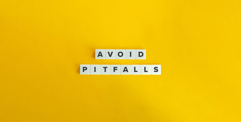 Avoid Pitfalls Phrase and Banner. Text on Block Letter Tiles on Yellow Background. Minimalist Aesthetics.