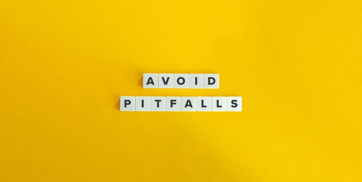 Avoid Pitfalls Phrase and Banner. Text on Block Letter Tiles on Yellow Background. Minimalist Aesthetics.