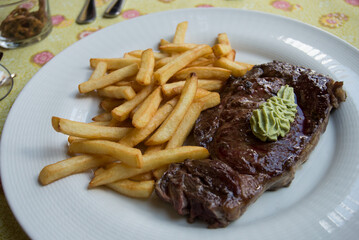 Closeup of entrecote and french fries in a plate at the restaurant