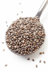 Chia seeds in iron spoon on white background. Close-up