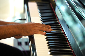 Male pianist playing piano, close-up