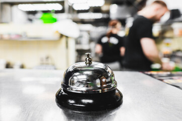 A service bell on a counter, set against an out-of-focus background with people. Relevant for...