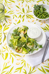 Green vegan breakfast meal in bowl with spinach, arugula, zucchini, seeds and sprouts of green pea. Clean eating, dieting, vegan food concept