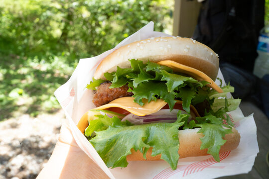 屋外で食べるチーズバーガー