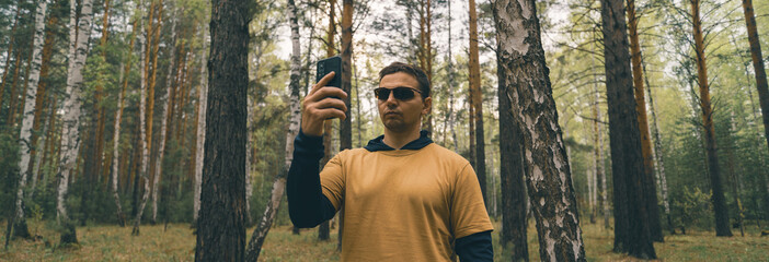 person with smart phone in the woods