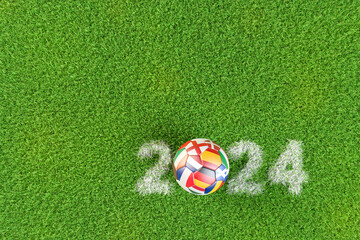 Soccer ball with the flags of several European Countries playing in Germany in 2024. The year 2024 displayed as chalk marking in the grass.
