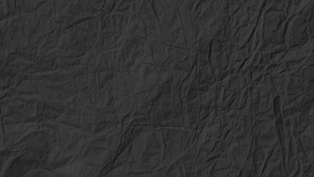 Stop motion animated paper texture background. Crumpled Black Paper Looping Animation in 4k. Quick changing.